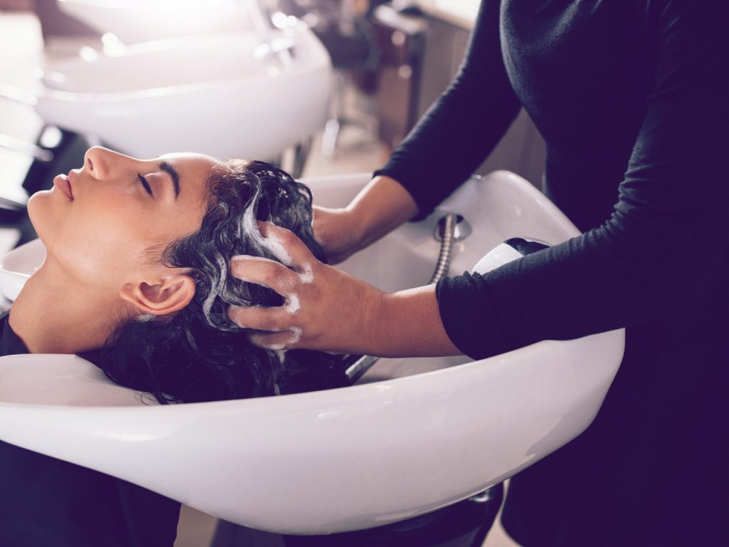 hairdresser washing female clients hair